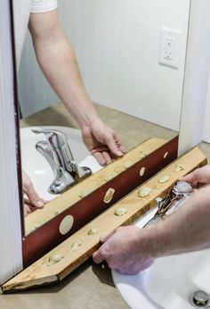 a man is working on fixing a sink in a bathroom with no faucet