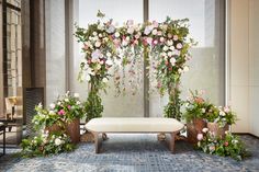 a white bench sitting in front of a window filled with flowers