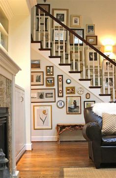 a living room filled with furniture and framed pictures on the wall next to a fire place