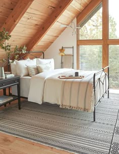 a bed sitting under a wooden ceiling in a bedroom