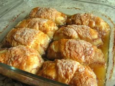 a glass dish filled with pastries covered in powdered sugar