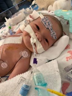 a baby in a hospital bed with an oxygen tube attached to its head and breathing apparatus on it's face