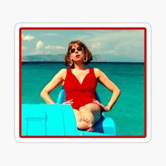 a woman in a red swimsuit is sitting on a blue boat with her hands on her hips