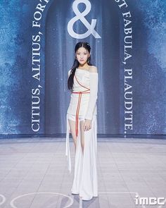 a woman in white dress standing on the runway