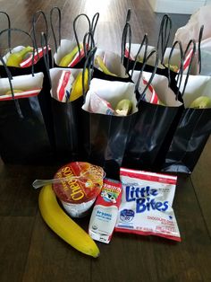 a bunch of bags that are sitting on a table next to some bananas and other items