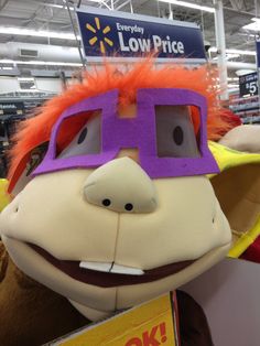 a stuffed animal wearing a purple and orange hat in a store aisle with the words low price written on it