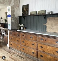 an old wooden dresser sitting on top of a hard wood floor next to a wall