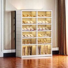 a white shelf filled with lots of shoes on top of a hard wood floor next to a window