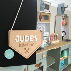 a wooden sign that says judge's kitchen hanging from the side of a cabinet