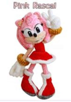 the pink rascal doll is wearing red boots and holding a white object in her hand