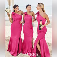 three beautiful women standing next to each other on the beach wearing pink dresses and holding champagne bottles