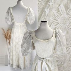 two white dresses on mannequins in front of wall with lace and flowers