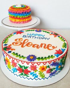 a birthday cake is decorated with flowers and the words happy birthday sloane on it