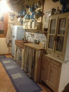 a kitchen with lots of pots and pans hanging on the wall