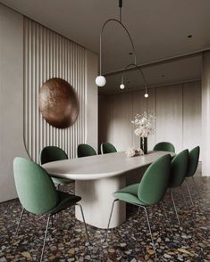 a dining room table with green chairs and a large round light fixture hanging from the ceiling