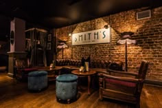 the interior of a restaurant with wooden floors and brick walls, leather seating and tables