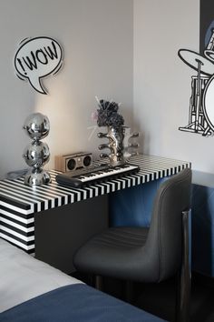 a room with a desk, chair and wall art on the walls in black and white