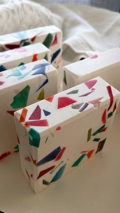 four pieces of colorful soap sitting on top of a white table