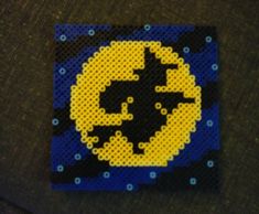 a piece of art made out of legos and some beads on top of a table