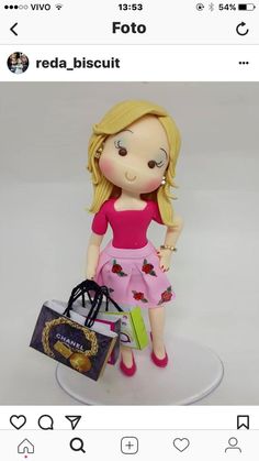 a doll with blonde hair holding a shopping bag and wearing pink shoes, sitting on top of a white plate