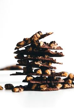 a stack of cookies sitting on top of each other next to chocolate chips and nuts