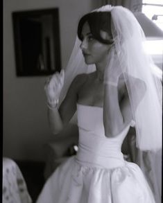 a woman in a wedding dress looking at her reflection