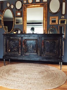 a room with blue walls and mirrors on the wall, rug in front of it