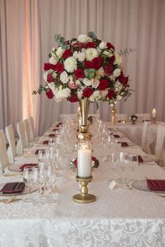 the centerpieces on this table are filled with red and white flowers