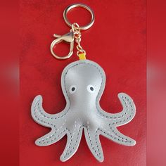 an octopus keychain is shown on a red surface