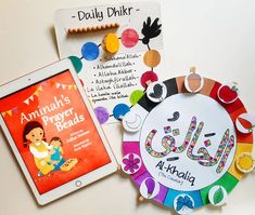 two children's books are sitting next to an ipad on a white surface,