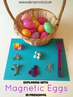 an easter basket filled with colorful eggs on top of a blue mat next to other items