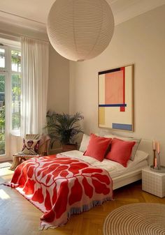 a bedroom with a large bed and red pillows on top of the bedspread