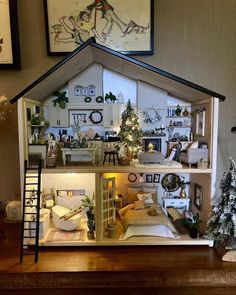 a doll house with furniture and decorations on the top floor, in front of a christmas tree