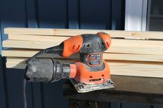 an electric sander on top of a wooden bench