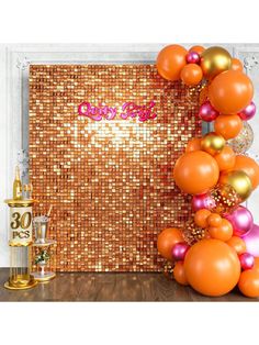 an orange and gold party decoration with balloons