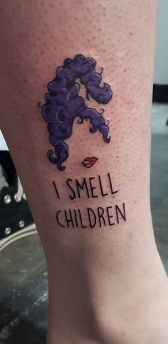 i smell children tattoo on the leg of a woman with purple hair and red lips