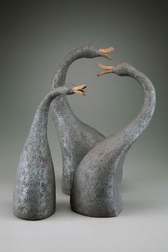 two birds are touching each other's necks in the shape of heart shaped figures