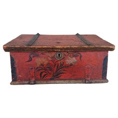 an old wooden box with floral designs painted on the side and metal latches at the bottom