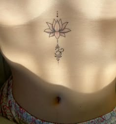 a woman's stomach with a lotus tattoo on it