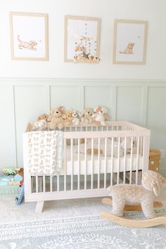 a baby crib with stuffed animals and pictures on the wall