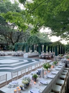 an outdoor dining area with tables and chairs set up for a formal function in the shade