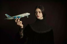 a woman holding a model airplane in her hand