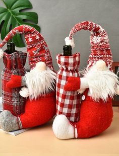 two red and white christmas wine bottles sitting on top of a table