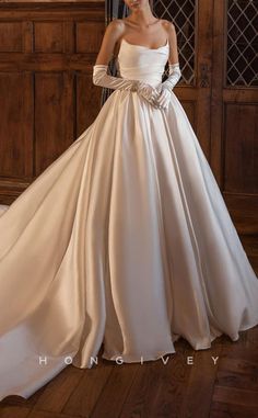 a woman in a white wedding dress standing on a wooden floor