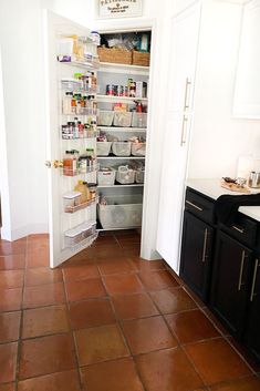 an open pantry door in a kitchen with lots of food on the shelves and drawers