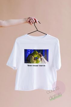 someone is holding up a t - shirt with an image of a frog on it