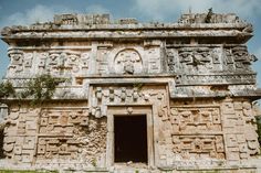 an old stone building with carvings on the front and side walls, including a doorway