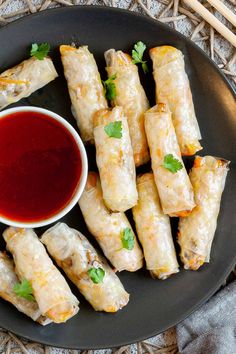 a plate full of spring rolls with dipping sauce