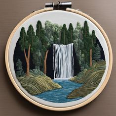 a hand embroidered picture of a waterfall in the woods with trees and water on it