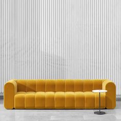 a yellow couch sitting in front of a white wall